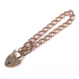 A 9ct Rose gold curb link bracelet with 9ct gold padlock and safety chain.