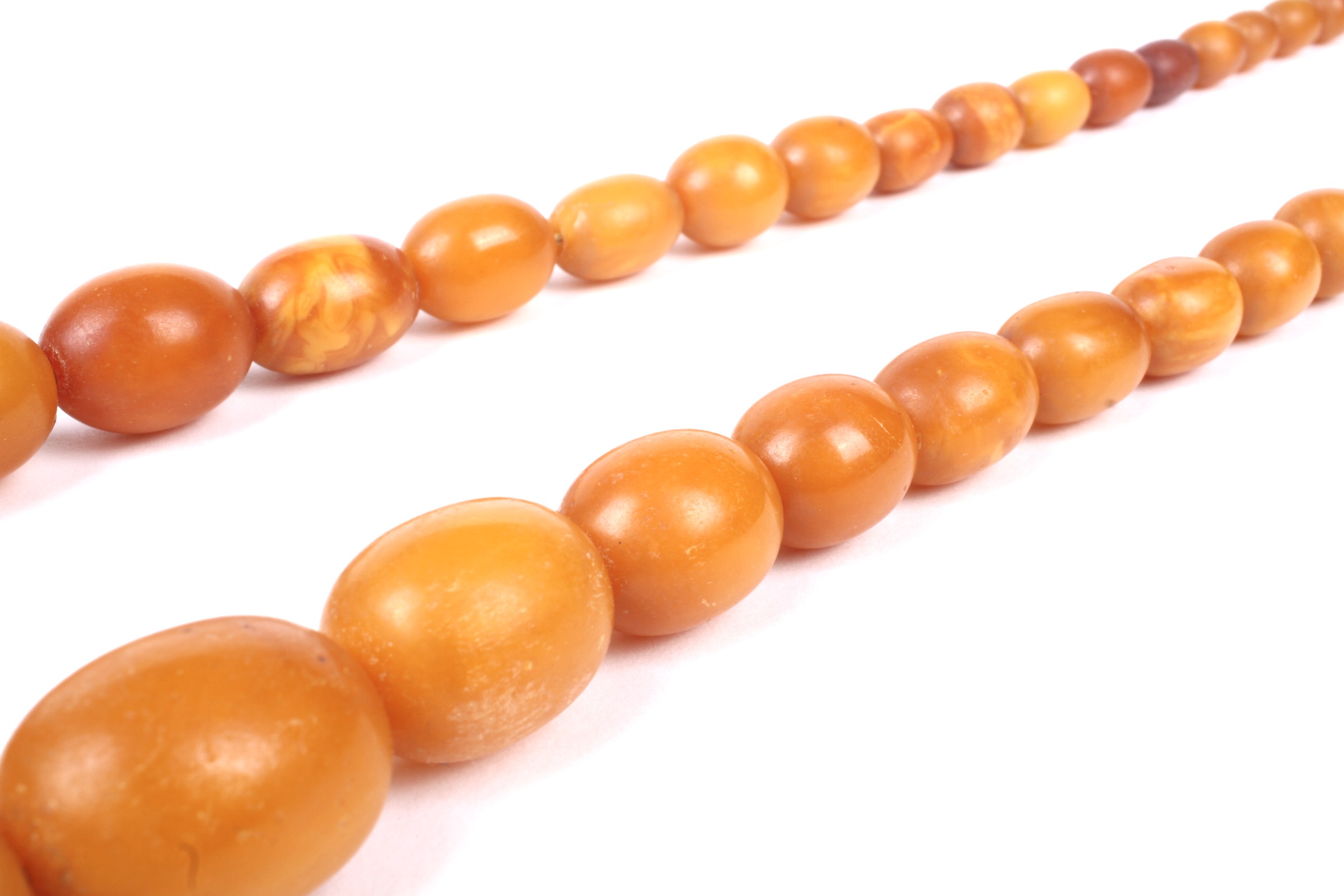 A amber oval bead necklace, the 46 varigated butterscotch-coloured oval beads - Image 2 of 14