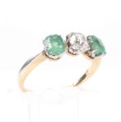 An early 20th century gold, emerald and diamond three stone ring.