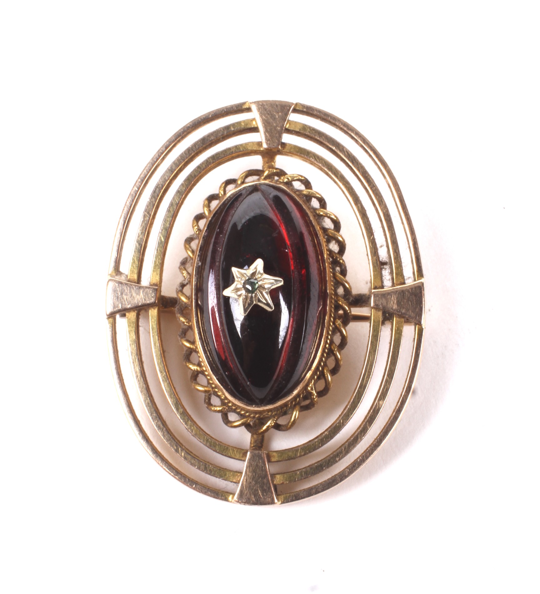 An early 20th century gold and garnet oval brooch.