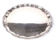 An Egyptian silver tray. Of circular scalloped form with reeded flowerhead and ribbon rim,
