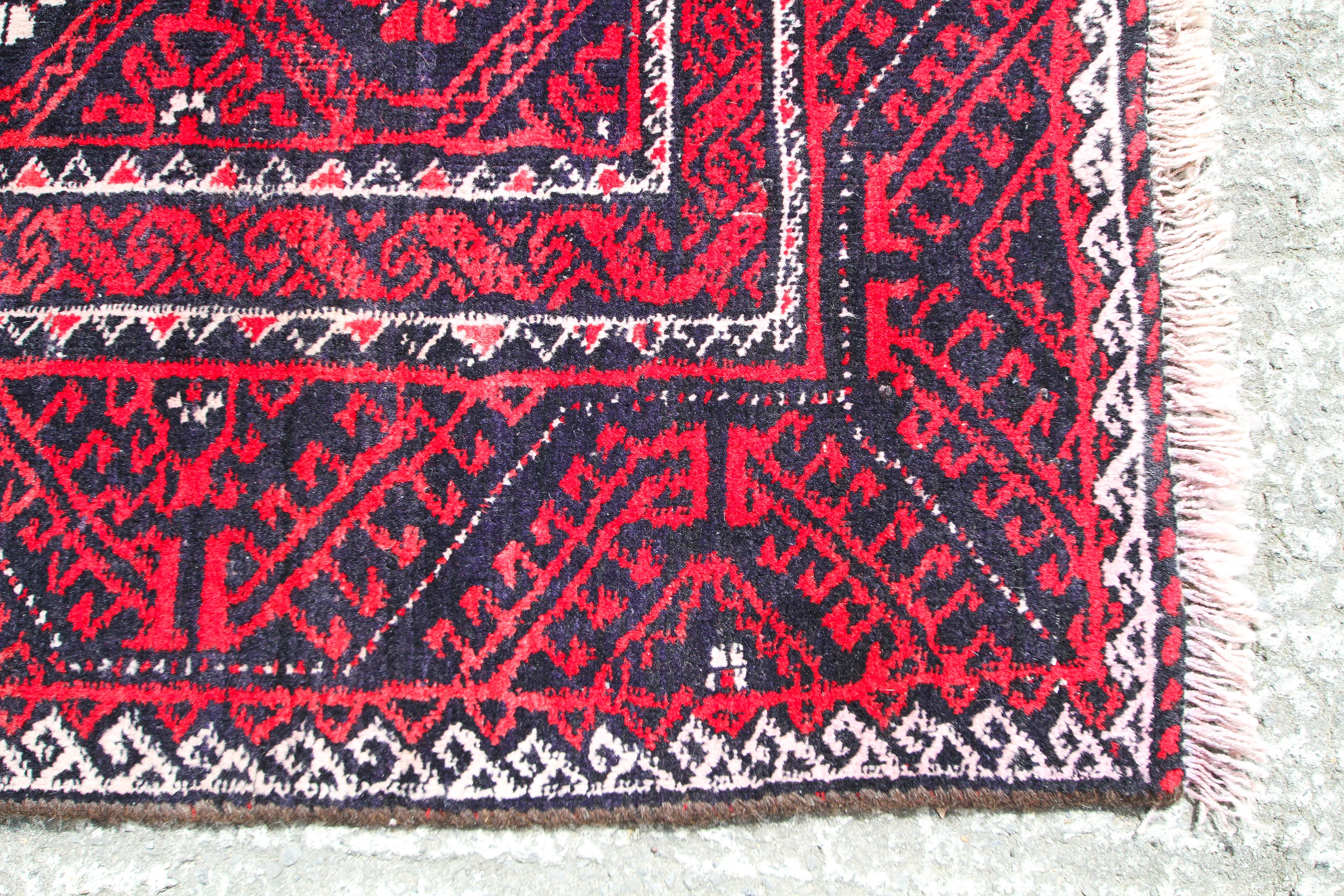 A Blooch red ground rug. - Image 3 of 3