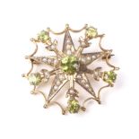 An early 20th century gold, peridot and half-pearl floral star brooch.