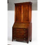 A Victorian mahogany bookcase on a Georgian bureau base.