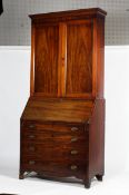 A Victorian mahogany bookcase on a Georgian bureau base.