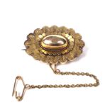 A Victorian gold oval brooch in archaeological revival style.