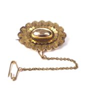 A Victorian gold oval brooch in archaeological revival style.