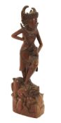 A 20th century Indonesian carved wooden figure of a dancer.