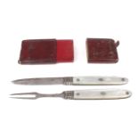 A Georgian silver and mother of pearl mounted folding travelling fruit knife and fork set in red