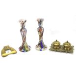 Two brass inkwells and a pair of coloured glass candlesticks.