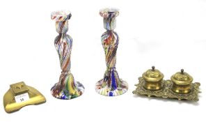 Two brass inkwells and a pair of coloured glass candlesticks.