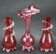 A pair of cranberry glass vases and one other.