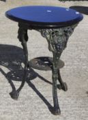 A black painted cast iron table with later wooden top.