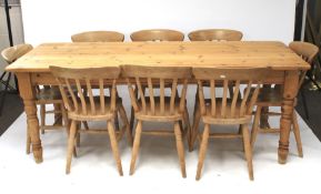 A large 20th century pine kitchen table and eight chairs.