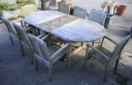 A large garden teak dining table with eight chairs.