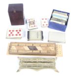 A collection of vintage playing cards, wooden cribbage boards and other items.