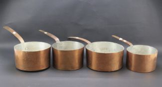 Four vintage copper saucepans.
