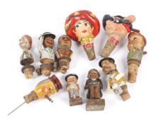 A collection of carved and painted wooden novelty wine bottle stoppers and others similar.