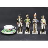 Four ceramic figures of French soldiers and a cup and saucer.