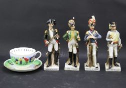 Four ceramic figures of French soldiers and a cup and saucer.