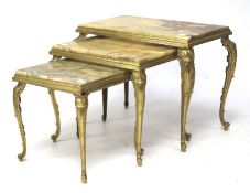 A nest of three gilt metal mounted stone topped tables.