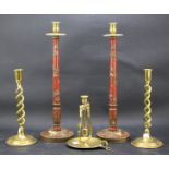 A pair of painted brass candlesticks and three single brass candlesticks.