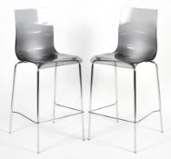 A pair of contemporary coloured perspex chrome kitchen bar stools.