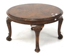 A low circular walnut occasional table. Raised on four carved cabriole supports.