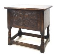 A 20th century carved oak floor standing sewing box with hinged cover.