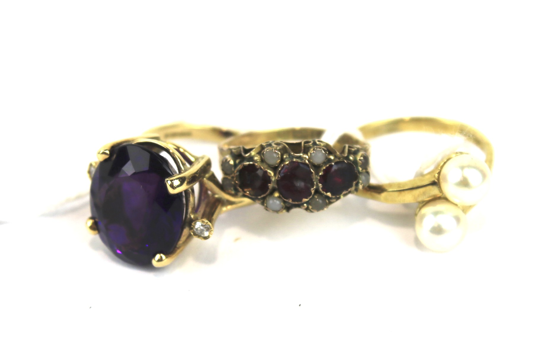 Three assorted 9ct gold rings, Including one dress ring set with a large purple stone,