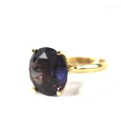 A yellow metal dress ring. Stamped '14ct', set with a large purple stone, size P,