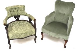 Two low, green upholstered button back tub chairs.