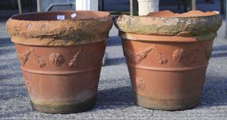 A pair of large terracotta pots. Of tapering cylindrical form, moulded with garlands,