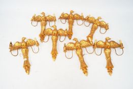 Seven gilt decorated wall lights all in the form of eagles with outstretched wings