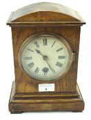 A stained oak cased mantel clock.