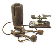A letter scale and weights together with a wooden cow bell.