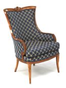 A 20th century armchair upholstered in blue and cream. Carved with feathers and swags.