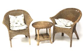 Two Lloyd Loom style wicker chairs and an occasional table. With floral patterned cushions.