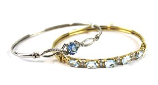 Two 9ct gold bangles. One in white gold, the other in yellow gold, both set with gemstones,