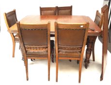 An Edwardian oak wind out dining table with extra leaf and set of six leather seated dining chairs.