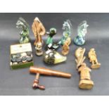 An assortment of paperweights and carved wooden figures.