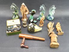 An assortment of paperweights and carved wooden figures.