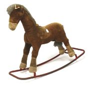 A mid-century rocking horse with honey coloured fabric and grey mane.