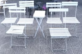 An assortment of six folding garden chairs and a similar table.