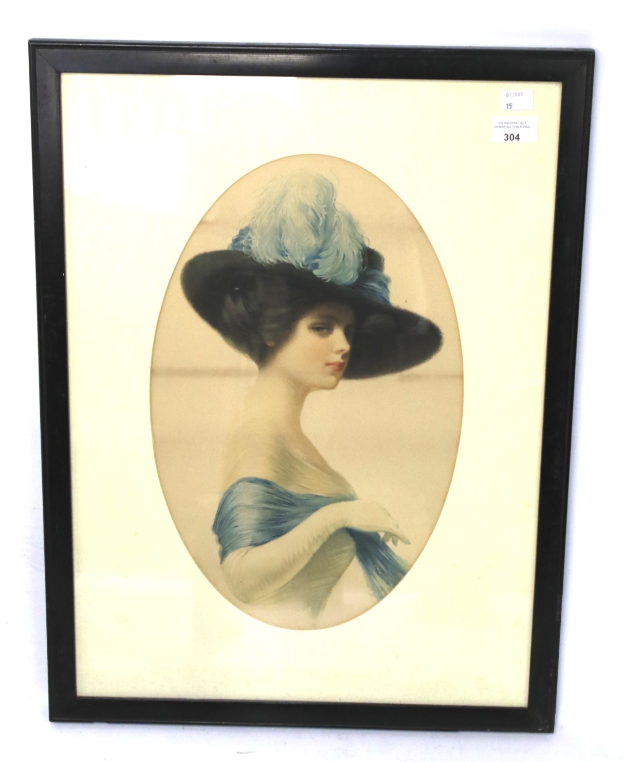 A framed print of an Edwardian lady wearing a black wide-brimmed blue feathered hat.