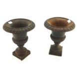 A pair of French cast iron urns. Formed of two parts on a square base.