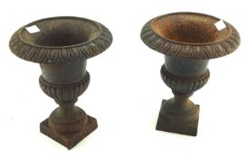 A pair of French cast iron urns. Formed of two parts on a square base.