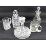 Three glass decanters and two tankards.