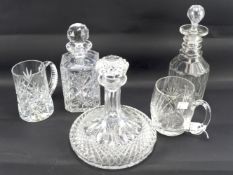 Three glass decanters and two tankards.