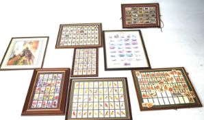 A collection of framed and glazed cigarette cards and other prints.
